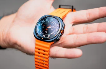Black and orange smartwatch displaying data on a hand.