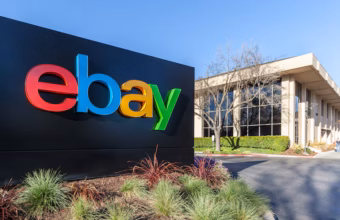 Panneau du logo eBay color&eacute; devant un b&acirc;timent de bureaux.