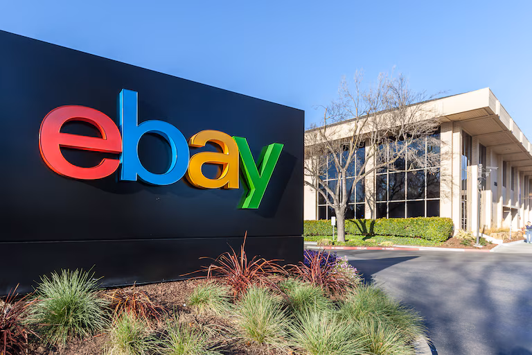 Panneau du logo eBay color&eacute; devant un b&acirc;timent de bureaux.